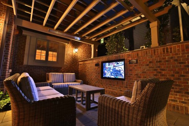 tv on brick wall on patio at night