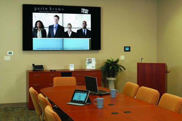 Commercial board room with multiple tiles on the TV and smart room control