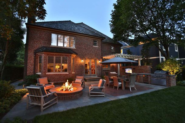 brick house with firepit at dusk